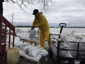 Dave McKay sandbags behind his cottage on Moorhead Driver near Fitzroy Harbour on Saturday.