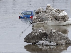 A flooded car sit in the flooded main road, Tuesday, April 16, 2019 in Beauceville Que. The Chaudiere River flooded and forced the evacuation of 230 buildings and 36 people.