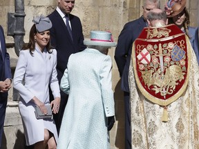 Britain's Kate, The Duchess of Cambridge curtsies as Britain's Queen Elizabeth II arrives to attend the Easter Mattins Service at St. George's Chapel, at Windsor Castle in England Sunday, April 21, 2019.