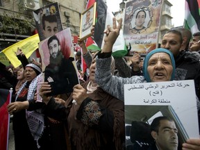 Relatives of Palestinians held in Israeli jails hold their portraits during a protest to mark "Prisoners Day" in the West Bank city of Ramallah, Wednesday, April 7, 2019.