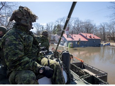 Canadian Forces members looks on from their Light Armoured Vehicle as they pass the Lighthouse Restaurant and Grocery in the Ottawa community of Constance Bay, during a guided tour of Canadian Armed Forces flood relief operations in the National Capital Region on Tuesday, April 30, 2019.