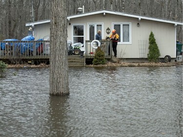 An Ottawa Police officer conducts a wellness check at a home surrounded by water in the Ottawa community of Constance Bay as flooding continues to affect the region, on Saturday, April 27, 2019.