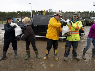 Volunteers form a human chain to load sandbags into a vehicle at the community centre in Ottawa's Constance Bay as flooding continues to affect the region, on Saturday, April 27, 2019.