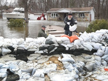 Volunteers and home owners build a sand wall to try and keep the rising water out on Boise Lane in Cumberland Saturday April 27, 2019.