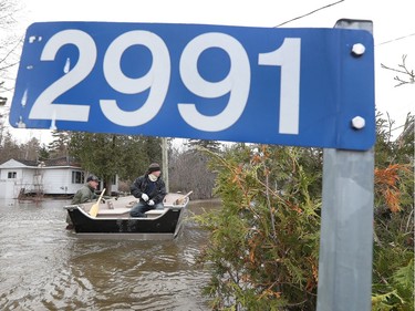 Volunteers and home owners traveling down Boise Lane by boat in Cumberland Saturday April 27, 2019.