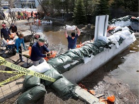 Residents and volunteers put sand bags along the  Britannia berm in Ottawa Monday. The wall on Jamieson Street is the weakest part of the berm which if destroyed will flood the entire neighbourhood of Britannia.