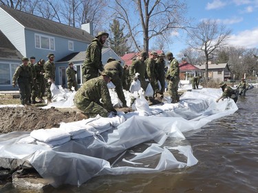 Armed forces personnel place sandbags to prevent flooding in Constance Bay.