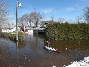 Media traveling with the Canadian Armed Forces during a flooding tour of Constance Bay in Ottawa Tuesday April 30, 2019. Members got a opportunity to watch the Canadian Armed Forces flood relief operations Tuesday. A woman carries sandbags in a canoe to her home.