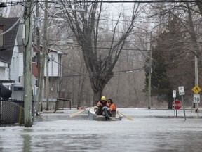 Utility workers used a boat to make their way along Rue Rene in Gatineau as flooding from the Ottawa River continued to affect the region on Saturday, April 27, 2019.