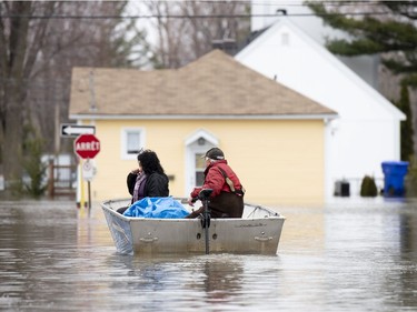 People use a boat to make their way along Rue Rene in Gatineau, Que. as flooding from the Ottawa River continues to affect the region on Saturday, April 27, 2019.