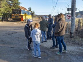 Area residents wait at a roadblock after orders to evacuate the area after an alert that the Bell-Chute dam is at risk of failing Thursday, April 25, 2019 in Grenville-sur-la-Rouge, Quebec.