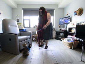 Opioid user Katrina Adams plays with her cat in Ottawa on Tuesday, April 23, 2019. Katrina Adams has thought about getting a commemorative tattoo for all of her friends who have died in the past two years from opioid overdoses but she doesn't think she would have enough room on her body for all the names. Instead, the 27-year-old has pictures of deceased friends in her Ottawa apartment along with images of her two children.