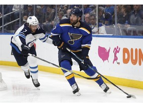 St. Louis Blues left wing Pat Maroon, right, is defended by Winnipeg Jets' Ben Chiarot, left, during the second period in Game 4 of an NHL first-round hockey playoff series Tuesday, April 16, 2019, in St. Louis.