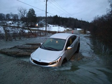 A car was stuck on Chemin-des-Rapides in Val-des-Monts on Saturday, April 20, 2109, after spring runoff washed away some of the dirt road.