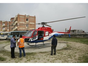 Hospital officials get ready to unload the dead body of a plane crash victim outside the Teaching Hospital in Kathmandu, Nepal, Sunday, April 14, 2019. At least three people were killed and four injured on Sunday after a small plane crashed into a parked helicopter during takeoff at the only airport in Nepal's Everest region.