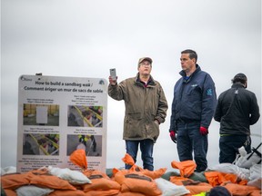 Jonathan Morris, president of the Britannia Village Community Association (left) along the berm holding back the flooding in Britannia, Thursday, May 2, 2019.