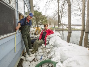 Clark Derraugh points to how high up on his and his wife Sharon's Dunrobin house the Ottawa River climbed after one of the sandbag walls protecting their home collapsed on April 30.