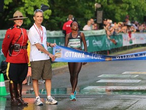 Peres Jepchirchir of Kenya collapses as she crosses the 10K race to win it and the Gender Challenge with a time of 31:28.9 during the 10K run, held in downtown Ottawa, during the Tamarack Ottawa Race Weekend, on May 28, 2016.