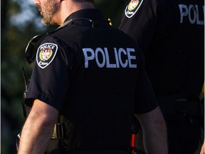 Two Ottawa police officers walked through the ground of RBC Bluesfest as the sun set Sunday July 8, 2018.  Ashley Fraser/Postmedia