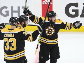 Brad Marchand of the Bruins is congratulated by teammates Patrice Bergeron  and Zdeno Chara (33) after scoring a third-period empty-net goal against the Blues on Monday night.