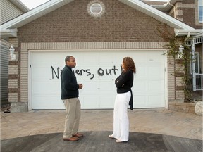 Rideau-Rockcliffe Coun. Rawlson King meets with Dr. Xaviere Kuate on May 6, two days after Kuate's garage door was defaced with racist graffiti.