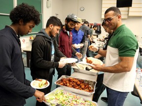 Gulled Saleban (L) of  Carleton University and Omar Dewidar of uOttawa help prepare the plates of food for Muslim students at an iftar dinner at uOttawa on Friday, May 24, 2019.