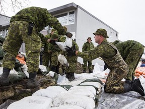 Members of the Canadian Armed Forces build a wall of sandbags to protect property against flood water in the Britannia area of Ottawa on May 1, 2019. Errol McGihon/Postmedia