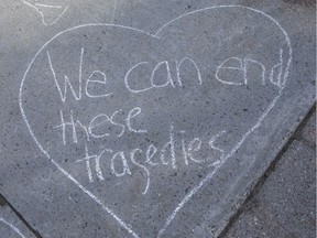 Messages in chalk on the sidewalk of Laurier Avenue in Ottawa where a man riding a bike was killed by a hit-and-run driver on May 16, 2019.