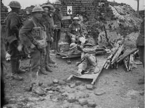 A badly wounded Canadian gives another wounded soldier a light during the push to Hill 70 at Lens, France, in August 2017.