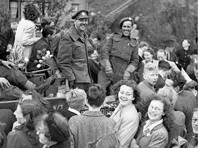 May 9, 1945: Infantrymen of The West Nova Scotia Regiment in a Universal Carrier en route to Rotterdam are surrounded by Dutch civilians celebrating the liberation of the Netherlands. (Lieut. G. Barry Gilroy / Canada. Dept. of National Defence / Library and Archives Canada / PA-134390)