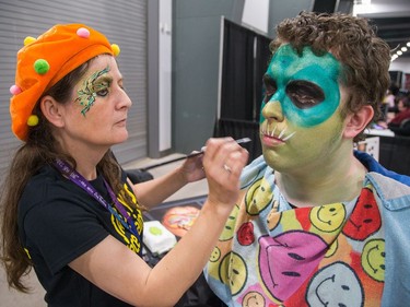 Face painter Jacqueline ten Hartog paints the face of Kyle Steinke as the 8th edition of Ottawa Comiccon gets underway at the EY Centre and runs through until Sunday.