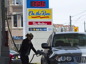 Files: A woman pumps gas