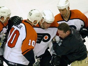 FILE - In this May 26, 2000, file photo, Philadelphia Flyers Eric Lindros, third from right, is assisted after getting hit in the first period of Game 7 of their NHL hockey Eastern Conference finals against the New Jersey Devils in Philadelphia. Lindros could easily be the poster boy for concussions in the NHL given his experience.