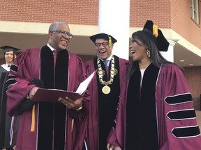 Robert F. Smith, left, laughs with David Thomas, center, and actress Angela Bassett at Morehouse College on Sunday, May 19, 2019, in Atlanta. Smith, a billionaire technology investor and philanthropist, said he will provide grants to wipe out the student debt of the entire graduating class at Morehouse College - an estimated $40 million. Smith, this year's commencement speaker, made the announcement Sunday morning while addressing nearly 400 graduating seniors of the all-male historically black college in Atlanta.