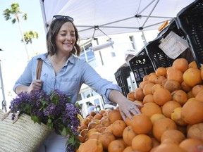 This April 10, 2019 photo shows Gaby Dalkin shopping for oranges at Santa Monica Downtown Farmers Market in Santa Monica, Calif. Dalkin, the chef behind the popular Website and social media accounts, "What's Gaby Cooking," is forging her own path. Every Monday she posts a live demo to Instagram as she cooks dinner which has become appointment viewing for some fans. Her husband films it and reads questions from viewers as she's cooking.