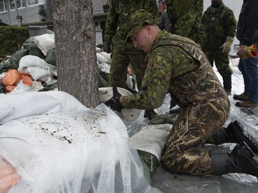Members of the Canadian Forces build a sandbag wall as they reinforce a dike protecting homes along the Ottawa River, Wednesday May 1, 2019 in Ottawa.