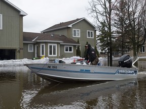 Pierre Benguay travels in his boat past a home threatened by floodwaters in Rockland on Thursday, May 2, 2019.