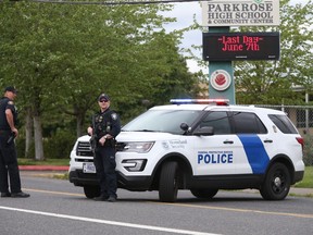 Police are positioned outside Parkrose High School Parkrose High School during a lockdown after a man armed with a gun was wrestled to the ground by a staff member, Friday, May 17, 2019 in Portland, Ore. The Portland Police Bureau said in a statement Friday that no shots were fired at Parkrose High School, no one was injured and the man is in custody. Police say there are no other suspects.