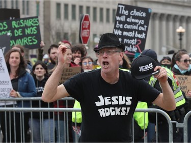 Hundreds of people gathered on Parliament Hill for the March for Life march in Ottawa Thursday May 9, 2019. A pro-life supporter (foreground) dances while the to pro-choice supporters chant in the background. Thursday.