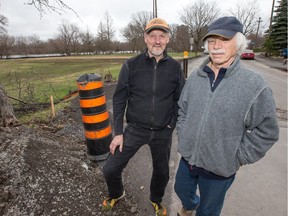 Russell Green, left, and Rob Hewett live on a street beside Brantwood Park, which floods almost every spring. But he and his neighbours say this year is worse because of work the city did on the park and the street, which rearranged the water table.