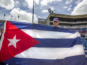 David Aldama, a diplomat with Cuba's embassy in Canada, waves his country's flag as he cheers on Cuba's national baseball team at Sunday's double-header against the Ottawa Champions.