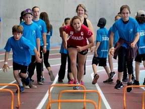 MONTREAL, QUE.: JUNE 20, 2017-- Canadian olympic triathlete Amelie Kretz takes part in track and field training exercises with kids attending the Laurent Duvernay-Tardif Foundation sports camp in Montreal on Tuesday June 20, 2017.