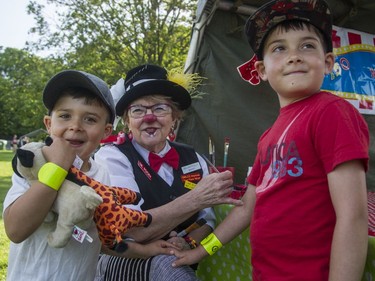Kyle and Jack Lafleur, 4 and 6, get their arms painted by Dr. Fooey at the annual CHEO Teddy Bear picnic at Rideau Hall on Saturday.
