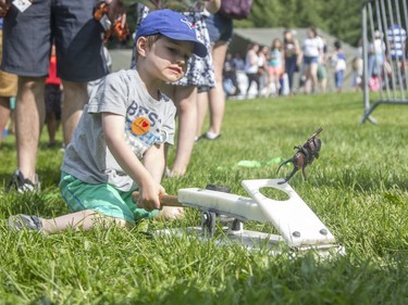 Four-year-old Evan Schnarr uses a mallet to see how far he can launch a plastic scarab beetle at the annual CHEO Teddy Bear picnic on Saturday.