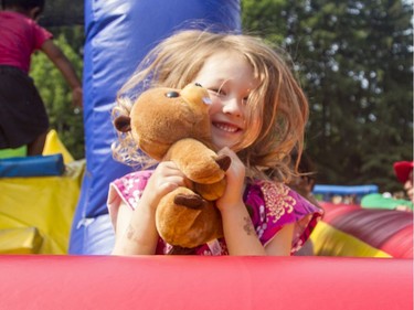 Olivia Perras, 4, has her moment in the sun in the bouncy castle at the annual CHEO Teddy Bear picnic at Rideau Hall on Saturday.
