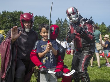 Briant Collins, 6, poses with a trio of superheroes seen wandering Rideau Hall grounds during the CHEO Teddy Bear picnic on Saturday.