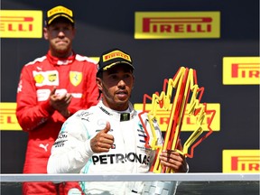 Lewis Hamilton celebrates on the podium as second-placed Sebastian Vettel applauds after the F1 Grand Prix of Canada at Circuit Gilles Villeneuve in Montreal on Sunday.