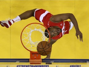 Kawhi Leonard attempts an acrobatic shot during Game 6 of the NBA Finals between the Raptors and the Warriors in Oakland on Thursday night.