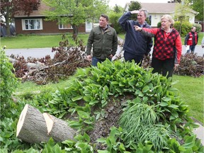 Kathy Fleming points out the damage to her Orléans home to Ottawa Mayor Jim Watson and Orléans Coun. Matthew Luloff on Monday.