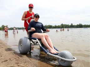 Xavier Latreille, waterfront lifeguard and Jessica Andersen, beach operational support staff show the accessible beach chair at Mooney's Bay. The chairs will soon be available at Britannia Beach and Petrie Island too.